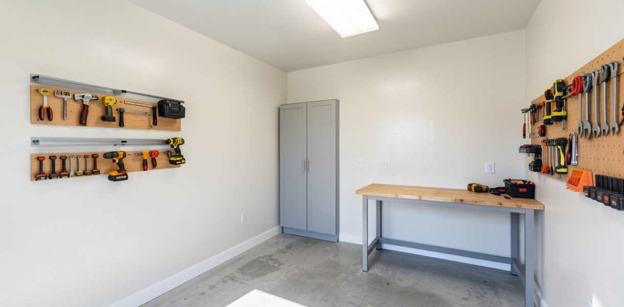 Intérieur de garage rénové et bien isolé, murs clairs, outils rangés et ambiance chantier propre et lumineuse.