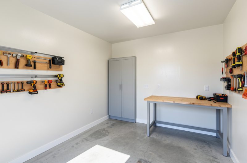 Intérieur de garage rénové et bien isolé, murs clairs, outils rangés et ambiance chantier propre et lumineuse.